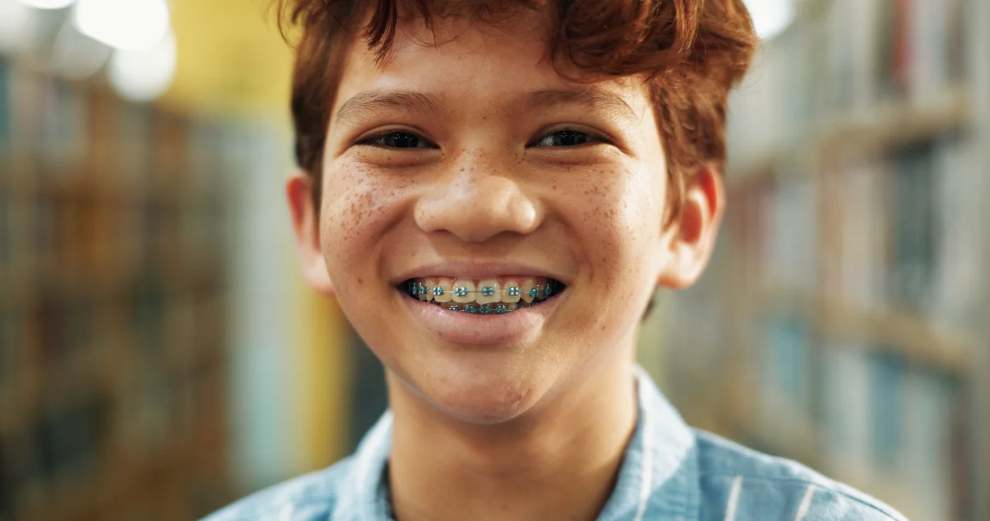 Smiling boy wearing braces outdoors
