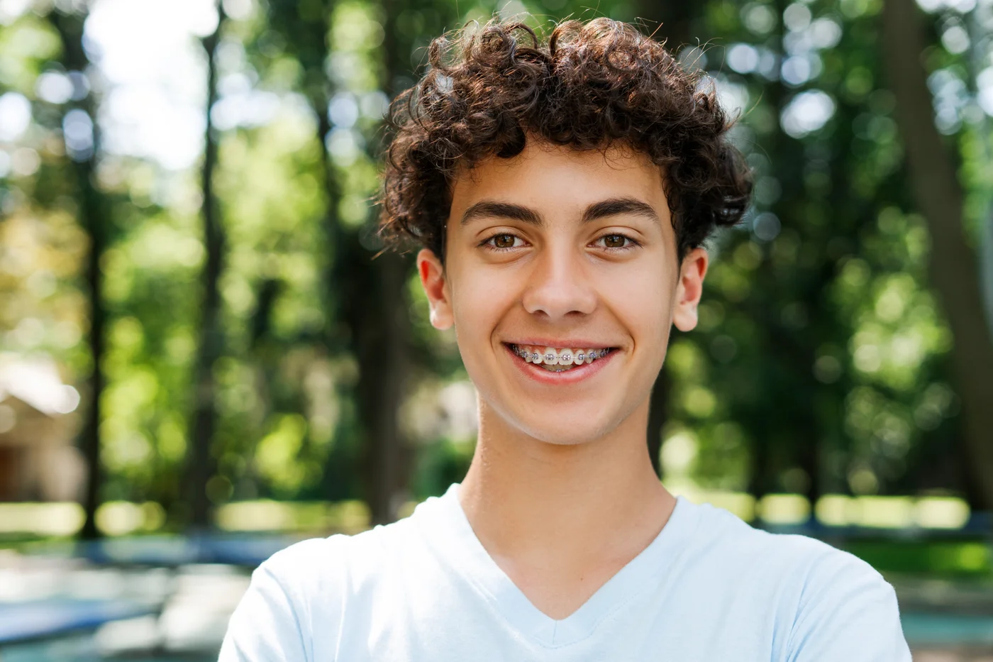 Teen smiling outdoors with visible braces