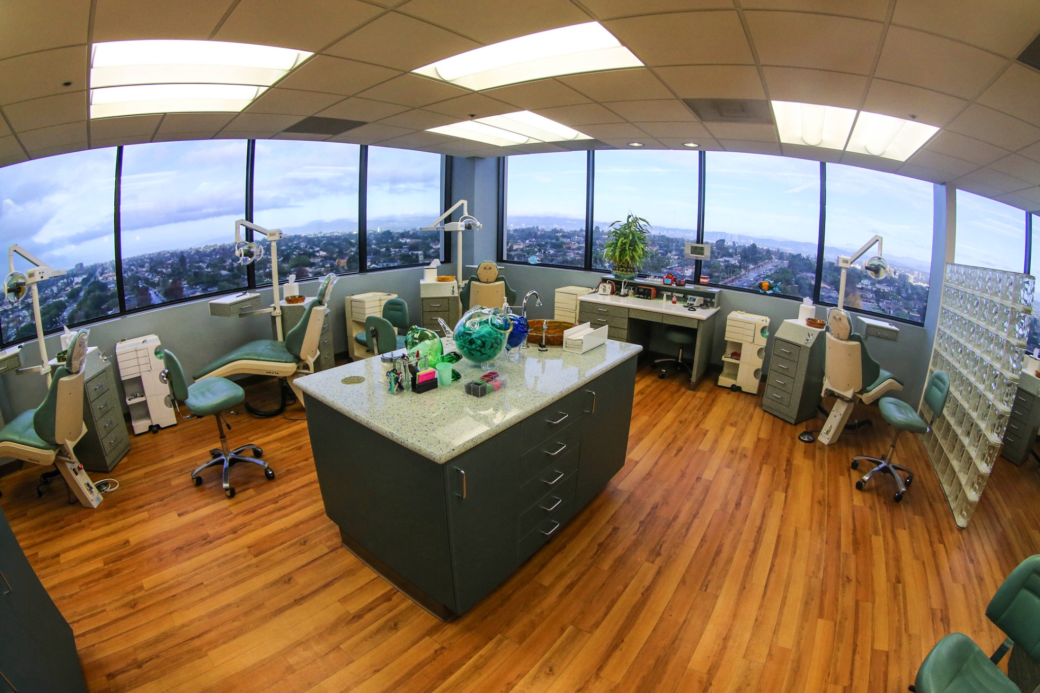 Orthodontic treatment room with dental chairs, a central work area and large windows overlooking Westchester
