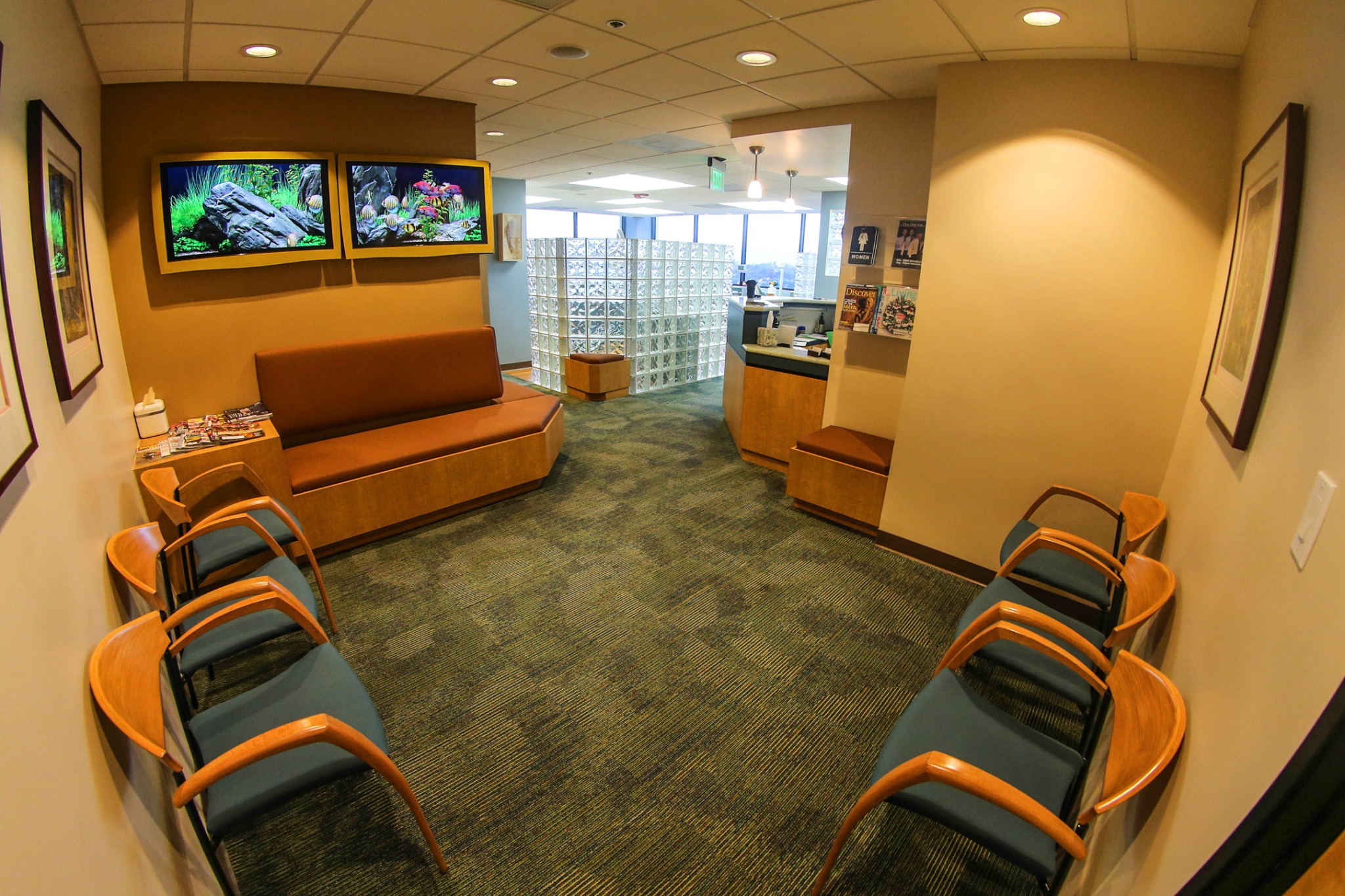 Westchester office waiting area with wood-framed chairs, cushioned seating and aquarium displays